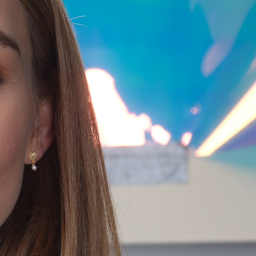 Nordahl Jewellery - Øreringe i forgyldt sølv RIPPLES52 båret af model i nærbillede