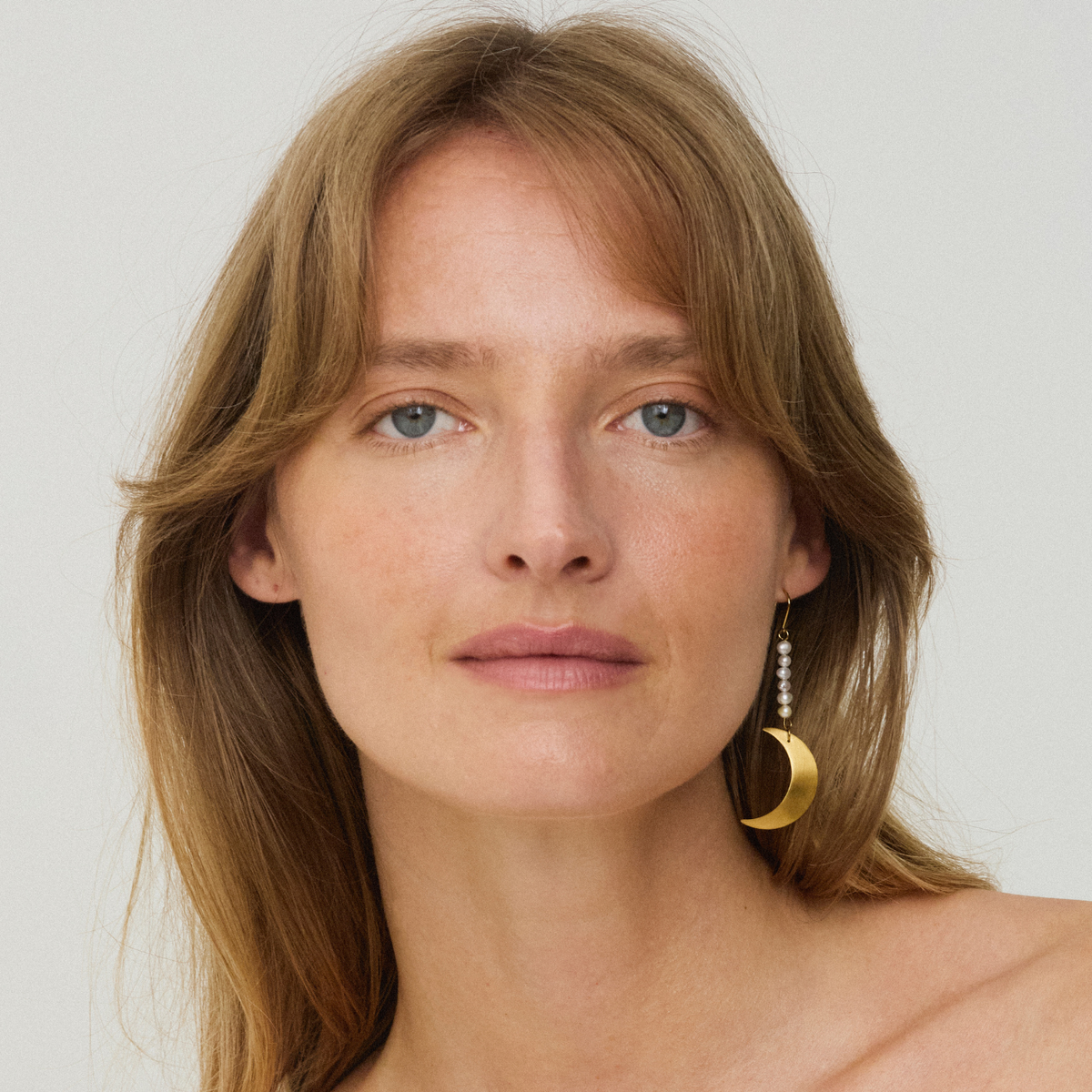 Jane Kønig Half Moon Pearl ørering i forgyldt stål på model