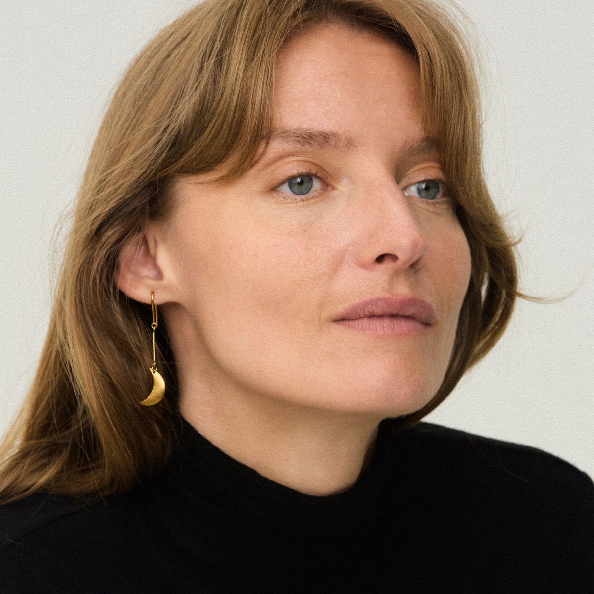 Jane Kønig Small Half Moon ørering i forgyldt stål på model